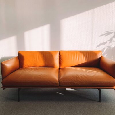 2-seat Orange Leather Sofa Beside Wall