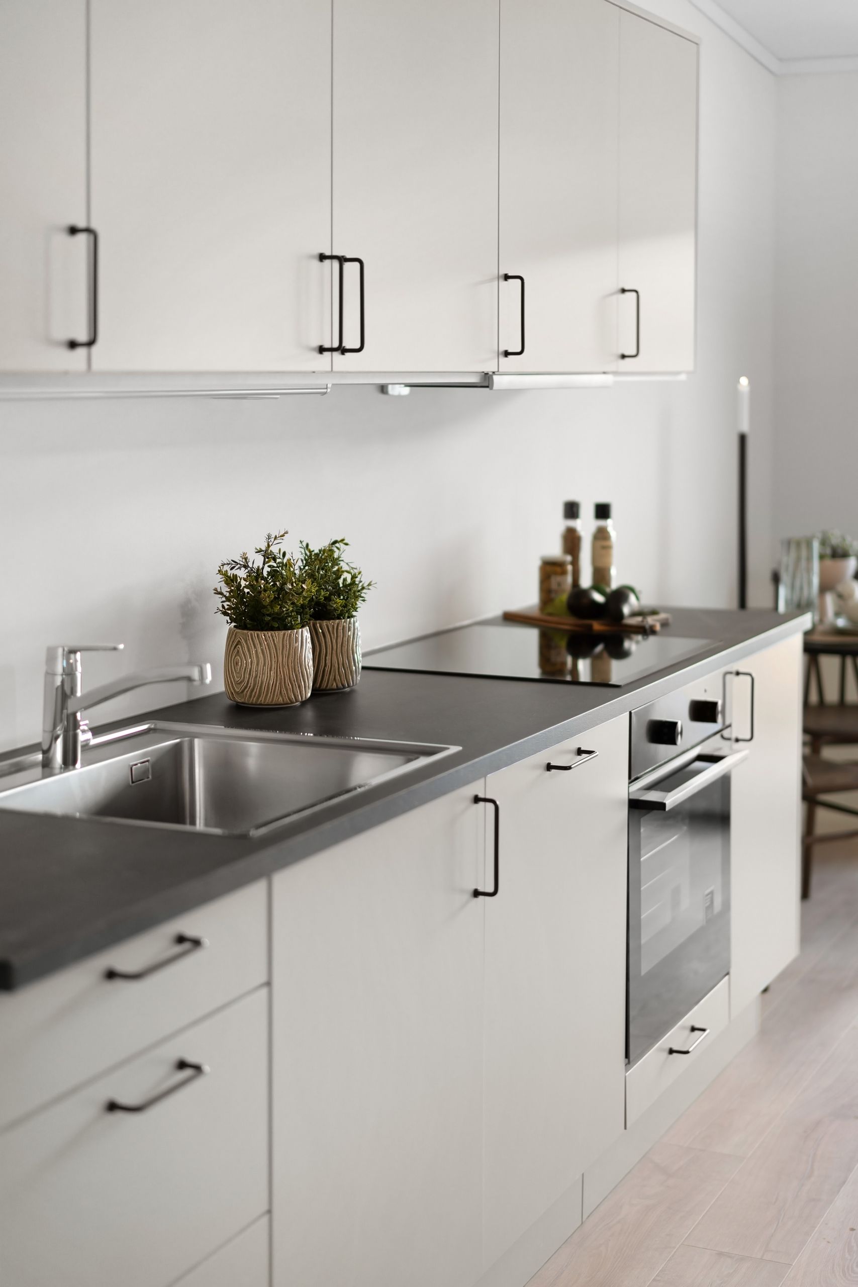 Sleek contemporary kitchen design featuring white cabinets and stainless steel appliances.