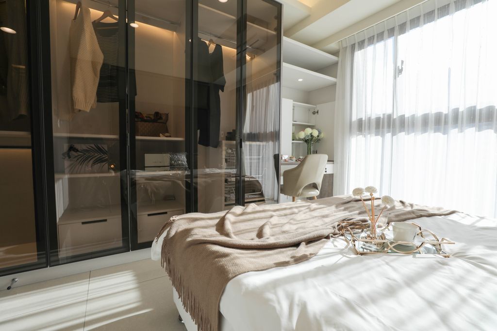 A sleek and stylish bedroom featuring a modern wardrobe and bright sunlight.